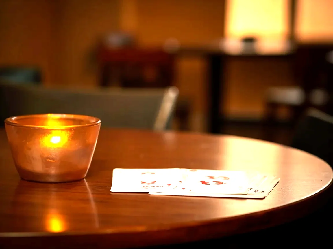 Editorial photograph of a real Indian card lounge interior, a polished wooden table with cards arranged in three neatly sorted melds